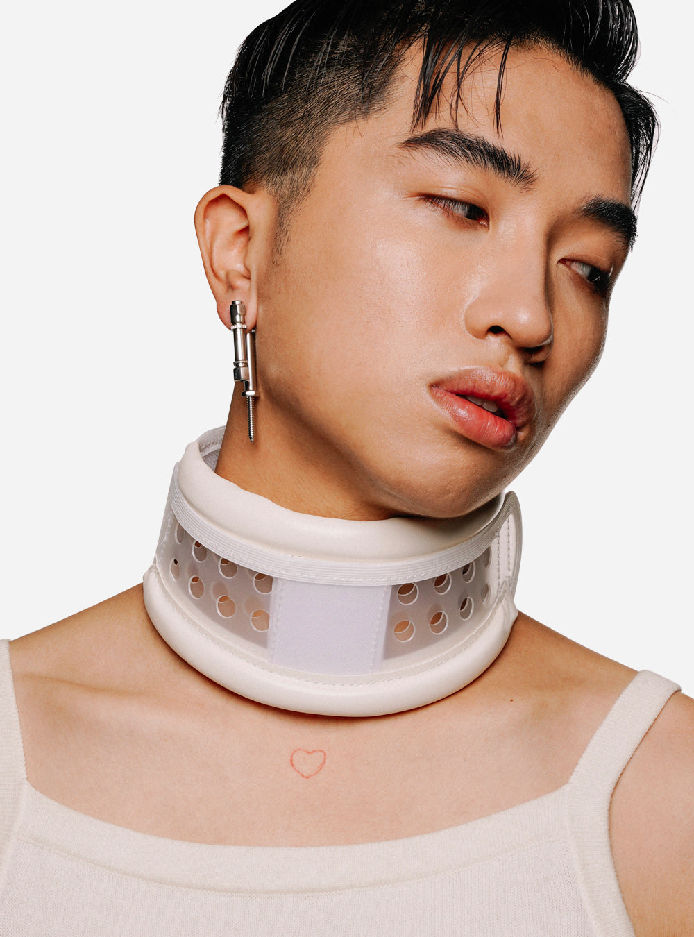 a man wearing a white Frankenscrew earring from MIDNIGHTFACTORY with piercings.