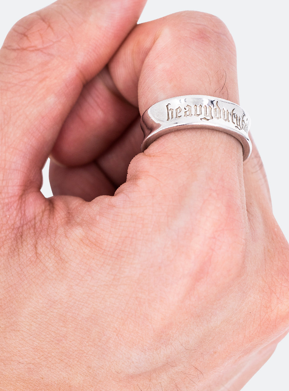 A person's hand holding an MIDNIGHTFACTORY HEAVYDUTYKID ring that says harry potter.