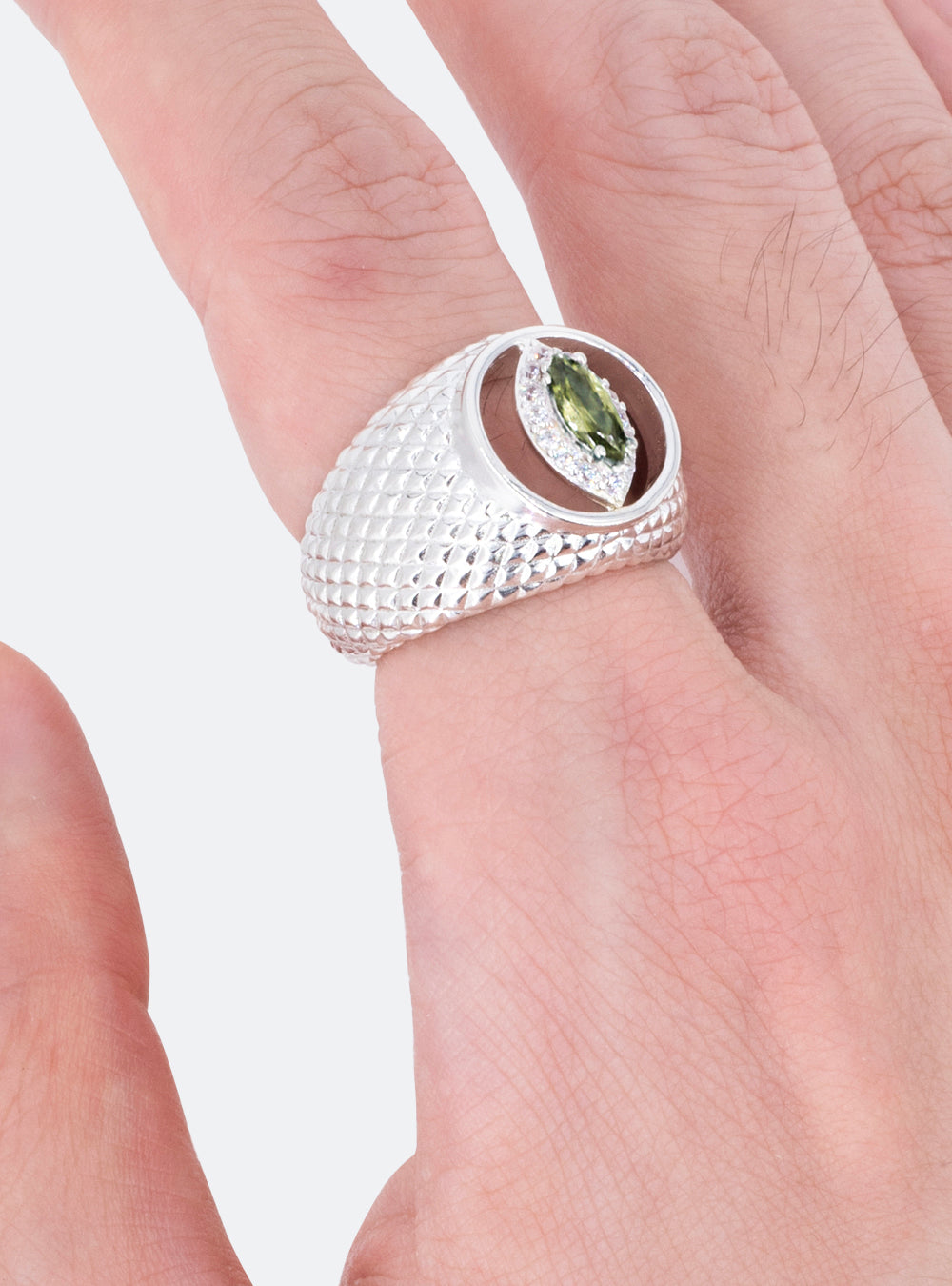 A man wearing a MIDNIGHTFACTORY cat-eye cutout cocktail signet ring with a green peridot stone.
