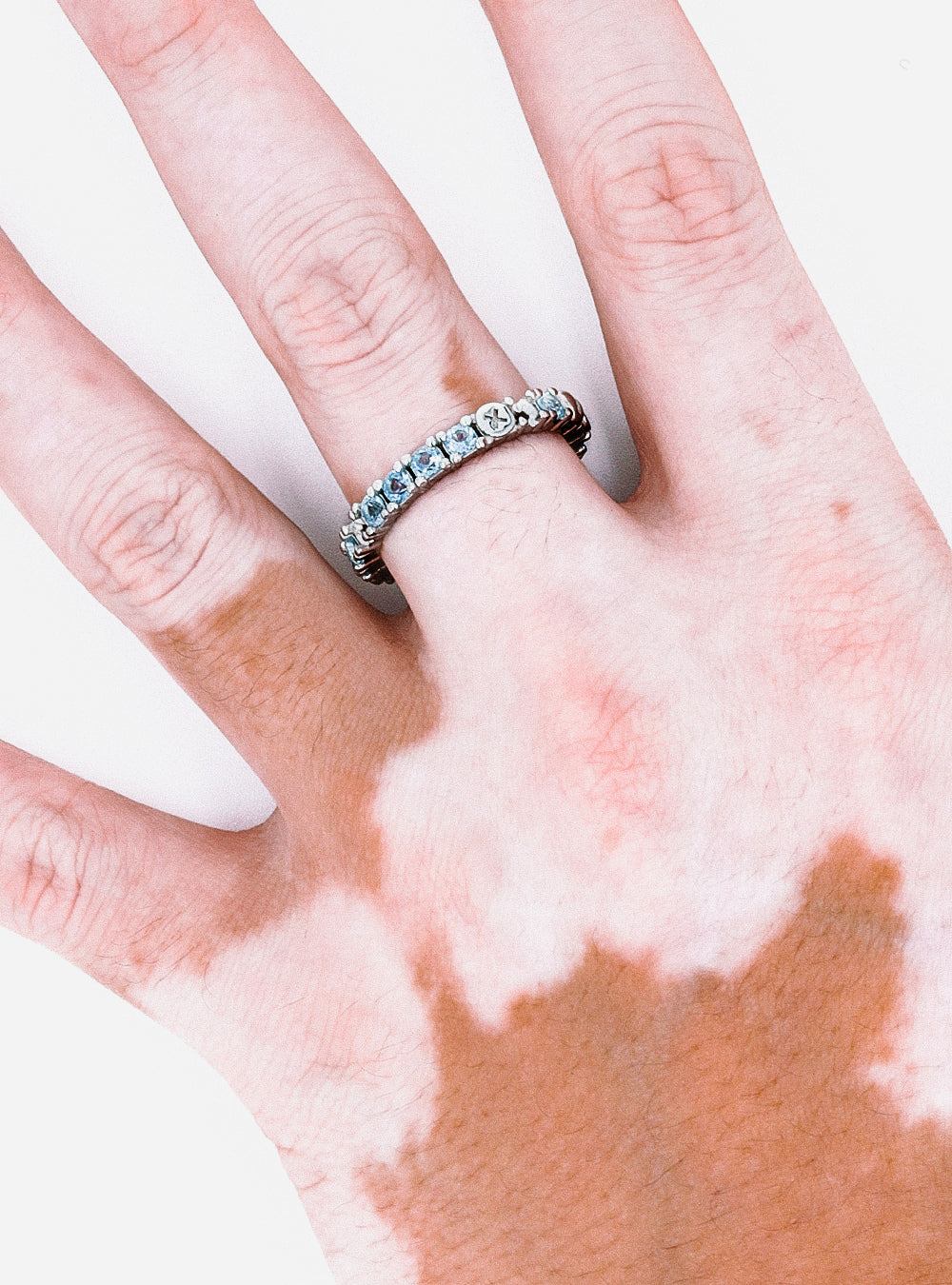 A woman's hand with a Broken eternity ring with topaz from MIDNIGHTFACTORY on it.