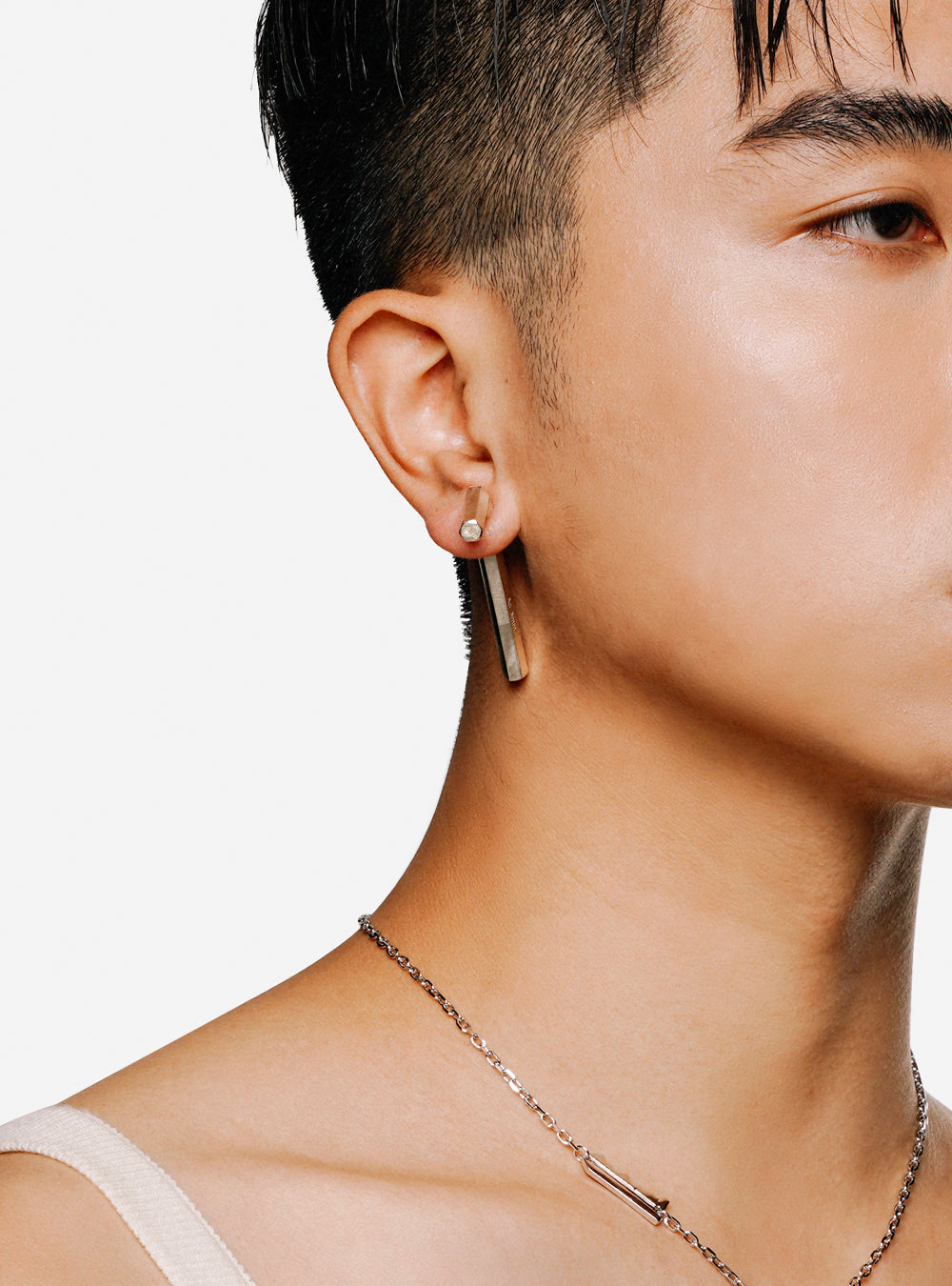 a man wearing a MIDNIGHTFACTORY HONG KONG Allen-key earring necklace and earrings.
