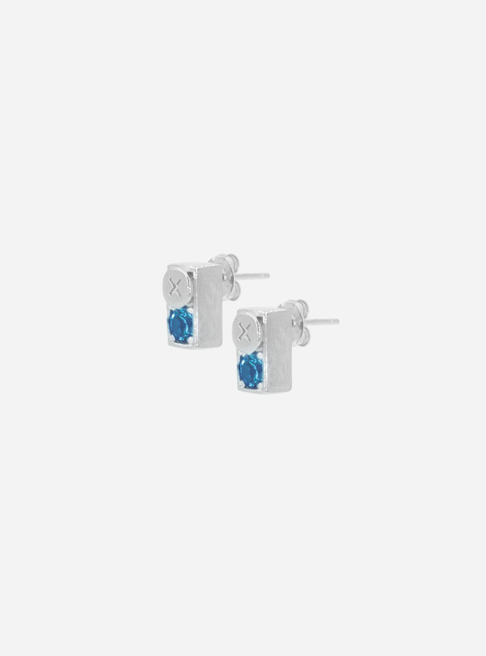 a pair of MIDNIGHTFACTORY Screwbox topaz earrings with blue stones.
